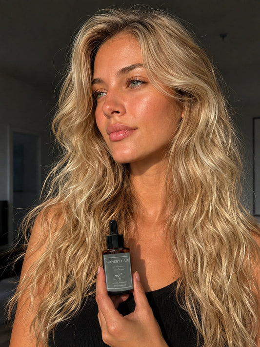Woman with long blonde hair holding Honest Hair & Co Hair Serum