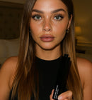 Woman holding mascara and showing her long eyelashes with the mascara applied